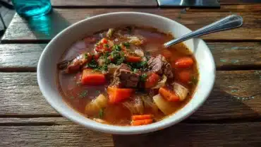 bowl of low calorie beef vegetable soup on wooden table