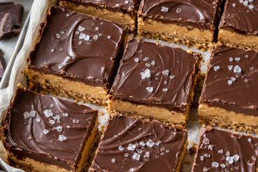 Photo of No Bake Desserts Recipes: Chocolate Peanut Butter Bars (no bake desserts recipes): A close overhead view of no bake desserts recipes featuring chocolate peanut butter bars cut into neat squares in a parchment-lined pan, with a crisp graham cracker base, thick peanut butter layer, glossy chocolate topping, and a few flaky salt crystals