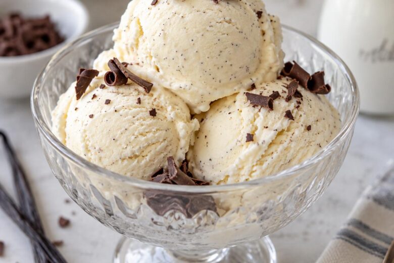 Vanilla Ice Cream Homemade No Eggs: Creamy 5-Ingredient Recipe 15 Photo of Vanilla Ice Cream Homemade No Eggs: Creamy 5-Ingredient Recipe (vanilla ice cream homemade no eggs): A close-up of vanilla ice cream homemade no eggs in a chilled glass dessert bowl, showing three creamy pale-ivory scoops with tiny vanilla bean flecks and delicate chocolate curls, softly lit on a light kitchen table