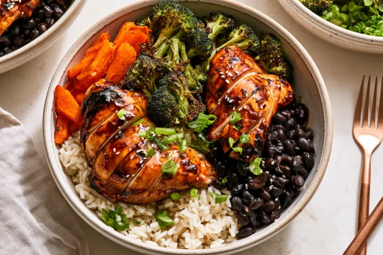High Fiber Chicken Recipes: Teriyaki Chicken Black Bean Bowls 19 Photo of High Fiber Chicken Recipes: Teriyaki Chicken Black Bean Bowls (high fiber chicken recipes): A warmly lit overhead view of high fiber chicken recipes as teriyaki chicken black bean brown rice bowls, with glazed sliced chicken thighs, black beans, roasted broccoli, carrots, scallions, and sesame seeds in ceramic bowls